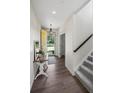 Bright entryway with wood floors and a staircase, featuring a yellow front door leading to a landscaped yard at 4830 Monarch Dr, Firestone, CO 80504