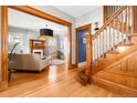 Open living room with hardwood floors, fireplace, and staircase at 3701 Eliot St, Denver, CO 80211