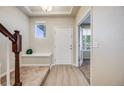 Bright entryway with wood floors, staircase, and a charming bench for added convenience at 3620 Sandoval St, Brighton, CO 80601