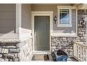 Inviting front entrance features a classic door, decorative stone accents, and stylish lighting at 3620 Sandoval St, Brighton, CO 80601