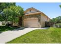 Attractive exterior view of a stone-accented home with an attached two-car garage at 517 Rider Ridge Dr, Longmont, CO 80504