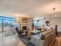 Bright living room features hardwood floors, fireplace, and expansive windows with city views at 1777 Larimer St # 1908, Denver, CO 80202