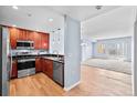 Stylish kitchen featuring stainless steel appliances, wood cabinets, and open to the living area at 975 N Lincoln St # 3E, Denver, CO 80203
