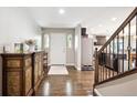 Welcoming entryway with hardwood floors, elegant console table, and open access to the kitchen at 22391 E Plymouth Cir, Aurora, CO 80016