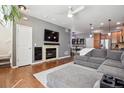 Cozy living room featuring a fireplace with stone surround, mounted TV, and open to the dining and kitchen areas at 16031 W 63Rd Ln # D, Arvada, CO 80403