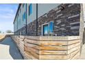 Low angle view showing the brick and siding of a residential building and partial fence at 4737 E Iliff Ave, Denver, CO 80222