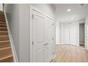 Hallway with new light wood flooring, gray walls, closet, stairs, and ample space at 4737 E Iliff Ave, Denver, CO 80222