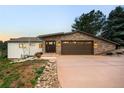 Lovely house with a stone facade two-car garage, and a pink colored driveway at 6491 Crestbrook Dr, Morrison, CO 80465