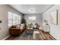 Inviting living room featuring a stylish brown leather sofa, neutral decor, and an abundance of natural light at 808 Hanover St, Aurora, CO 80010