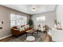 Inviting living room featuring a stylish brown leather sofa, neutral decor, and an abundance of natural light at 808 Hanover St, Aurora, CO 80010