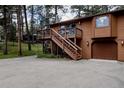 Two story home featuring an elevated deck, a wooden staircase, and an attached garage at 29101 Drexel Spur, Evergreen, CO 80439