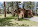 Well-maintained home exterior surrounded by lush greenery, mature trees, and an expansive lawn at 29101 Drexel Spur, Evergreen, CO 80439