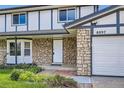 Close-up of the stone-accented facade with a white front door and a spacious two-car garage at 8897 Wagner Ln, Westminster, CO 80031