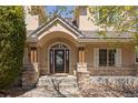Inviting entryway with an arched doorway, stone pillars, and decorative glass door that enhances its curb appeal at 21231 E Saddle Rock Ln, Aurora, CO 80016
