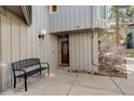 Charming entryway with a wooden front door, a bench, and fresh landscaping at 2378 Hearth Dr # 6, Evergreen, CO 80439