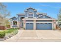 Inviting home boasts a two-car garage, manicured lawn, and stylish blue exterior at 9371 Desert Willow Trl, Highlands Ranch, CO 80129