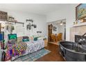 View of the bedroom leading to dining area with hardwood floors and fireplace at 8260 Washington St # 78, Denver, CO 80229