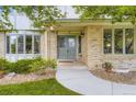 Inviting front porch with a double-door entrance, decorative landscaping, and a charming bay window at 5723 S Kittredge St, Centennial, CO 80015