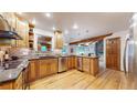 Well-lit kitchen with stainless steel appliances, hardwood floors, and dark countertop at 5723 S Kittredge St, Centennial, CO 80015