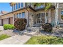 Inviting front porch with decorative metal door and welcoming landscaping at 2154 S Parfet Dr, Lakewood, CO 80227