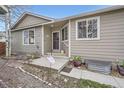 Inviting front porch with a concrete landing and decorative plants at 8345 Moore St, Arvada, CO 80005