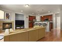 Open-concept living area with hardwood floors, fireplace, and kitchen bar-style seating at 3680 S Beeler St # 5, Denver, CO 80237