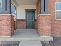 Welcoming front porch with classic brick columns, dark trim, and a stylish entrance door for a warm first impression at 383 Remuda Rd, Berthoud, CO 80513