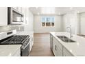 Bright kitchen featuring an island with bar seating, stainless steel appliances, and modern finishes at 383 Remuda Rd, Berthoud, CO 80513