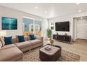 Bright living room with a sectional sofa, a large sliding glass door, neutral walls, and modern decor at 383 Remuda Rd, Berthoud, CO 80513