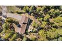 Overhead view of a house with a large yard with boulders, trees and a long driveway leading to the home at 25531 Mosier Cir, Conifer, CO 80433