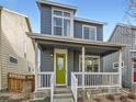Charming two-story home with blue siding, a green front door and a quaint covered front porch at 4723 Crestone Peak St, Brighton, CO 80601