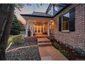Charming covered front porch with brick columns and tiled flooring, perfect for relaxing outdoors at 13955 Craig Way, Broomfield, CO 80020