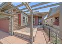 Inviting front porch with pergola and stone pillars at this home's entrance at 1130 Summit View Dr, Louisville, CO 80027