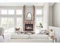 Bright living room showcasing a brick fireplace, large windows, and comfortable seating area at 3328 S Danube St, Aurora, CO 80013