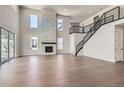 Bright, open living room features a stone fireplace, hardwood floors, and plenty of natural light at 4748 Weitbrec Ln, Castle Rock, CO 80104