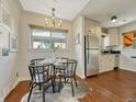 Cozy dining area with wood floors, stylish lighting, and a view into the kitchen at 732 Poplar St, Denver, CO 80220