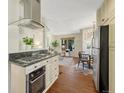 Open concept kitchen with gas range, stainless appliances, and hardwood floors at 732 Poplar St, Denver, CO 80220