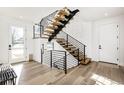 Modern floating staircase with black metal railings and light wood steps at 6435 E 6Th Avenue Pkwy, Denver, CO 80220