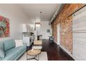 Open-concept living space with exposed brick and seamlessly flowing into kitchen and dining at 1810 E 33Rd Ave, Denver, CO 80205