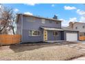 A beautifully renovated two-story home with a modern gray exterior, bright door and well-kept yard at 9288 W Wesley Dr, Lakewood, CO 80227