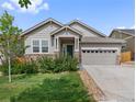 Charming single-story home boasts stone accents, a two-car garage, and a well-manicured lawn at 6484 S Harvest St, Aurora, CO 80016