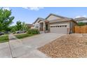 Ranch style home with a large driveway and landscaped front yard at 6484 S Harvest St, Aurora, CO 80016