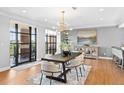 Dining area featuring modern light fixture, seating for six, and oversized windows leading to outdoor space at 1590 Little Raven St # 408, Denver, CO 80202