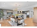 Open concept dining area with modern light fixture, seating for six, and adjacent to stylish kitchen at 1590 Little Raven St # 408, Denver, CO 80202