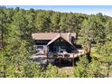 Aerial view of a two-story home nestled in a lush wooded area, complete with a deck at 2976 Hiwan Dr, Evergreen, CO 80439