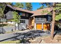 Charming exterior featuring a two-story home, a basketball hoop, and a two-car garage at 2976 Hiwan Dr, Evergreen, CO 80439