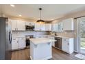 Bright, updated kitchen with white cabinets, stainless steel appliances, center island and light wood flooring at 1169 N Tabor Dr, Castle Rock, CO 80104