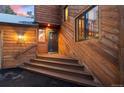 Exterior view of a two-story home showcasing the front door, steps, and wood facade at 31207 Kings Valley Dr, Conifer, CO 80433