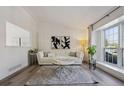 Bright and airy living room with modern flooring, white sofa, and ample natural light from the large window at 9222 Albion St, Thornton, CO 80229