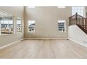 Bright, open-concept living room featuring hardwood floors and large windows overlooking the neighborhood at 39751 Congress Ln, Elizabeth, CO 80107